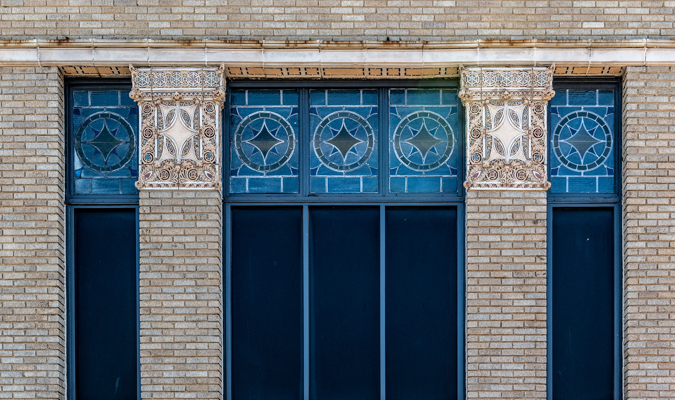 Historic brick facade of The Caz with ornate terra cotta capitals and blue star-pattern windows