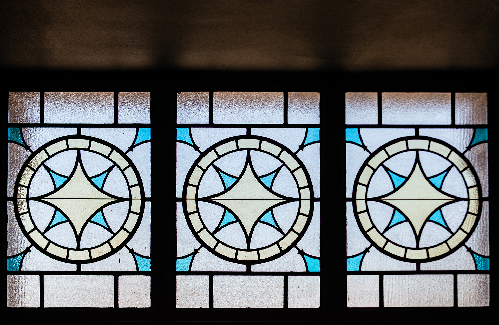 Three restored stained glass windows with star designs at The Caz