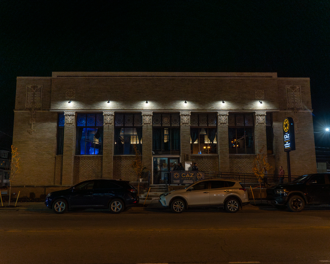 The Caz building lit up at night on Seneca Street