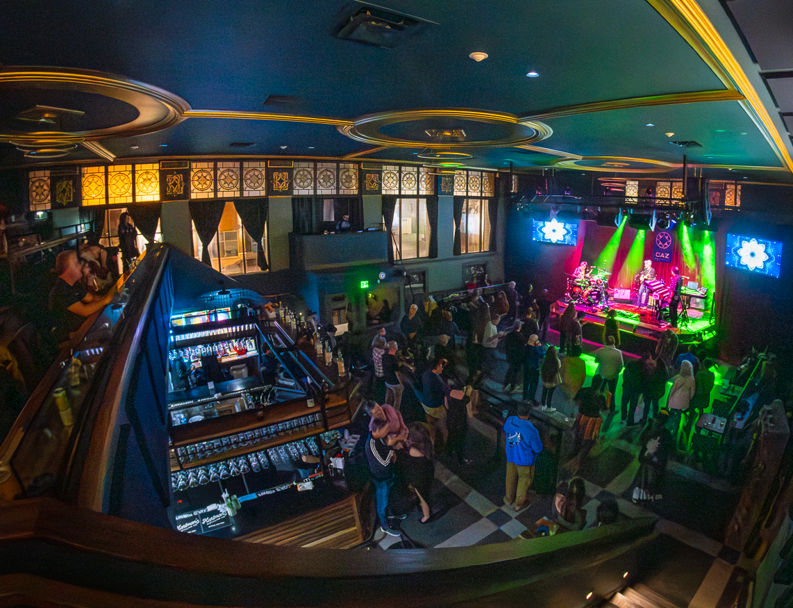 A crowd filling the main floor and bar during a show at The Caz