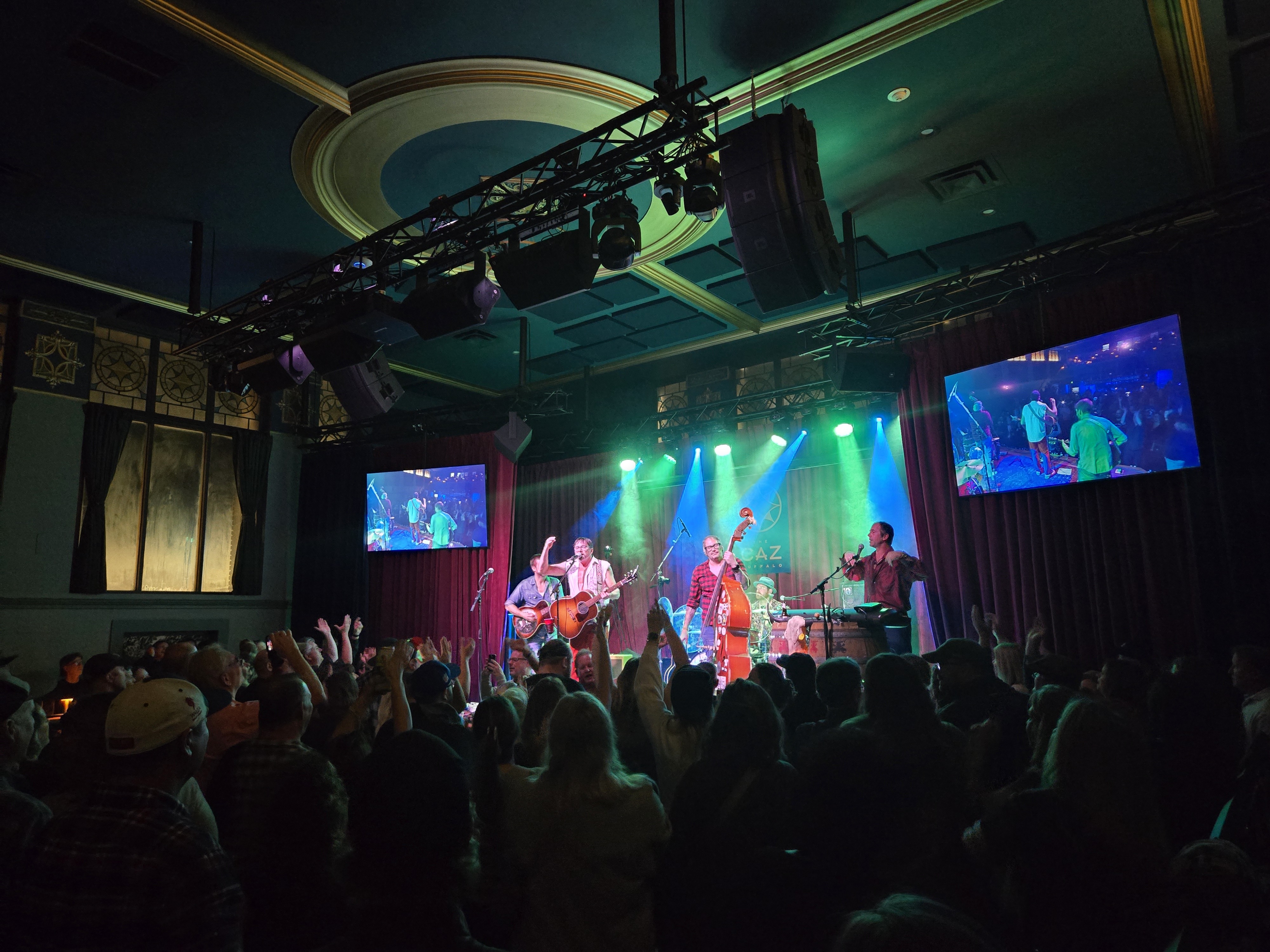 A bluegrass band performing to a cheering crowd at The Caz