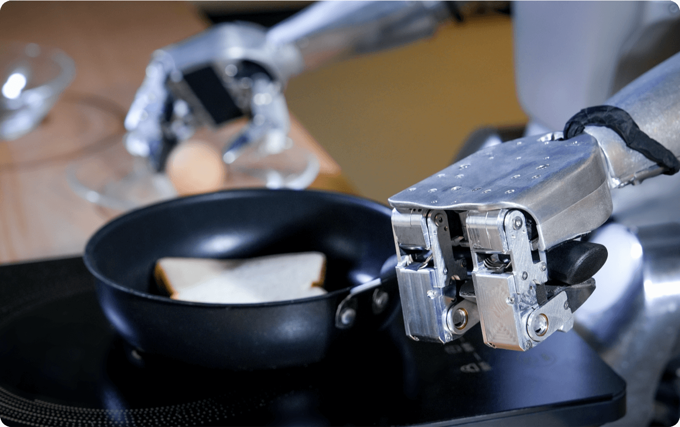 Unitree G1 humanoid robot performing a cooking task, using its dexterous robotic hands to manipulate a frying pan on a stovetop. The image shows the robot's 3-finger Dex3-1 hands gripping the pan handle while cooking food, demonstrating the practical manipulation capabilities enabled by imitation learning. This real-world task execution showcases the G1's potential for domestic assistance research and human-robot collaboration studies.