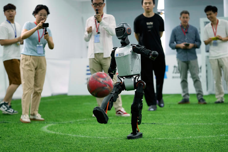 Booster K1 humanoid robot demonstrating bipedal locomotion and ball control capabilities 95cm height