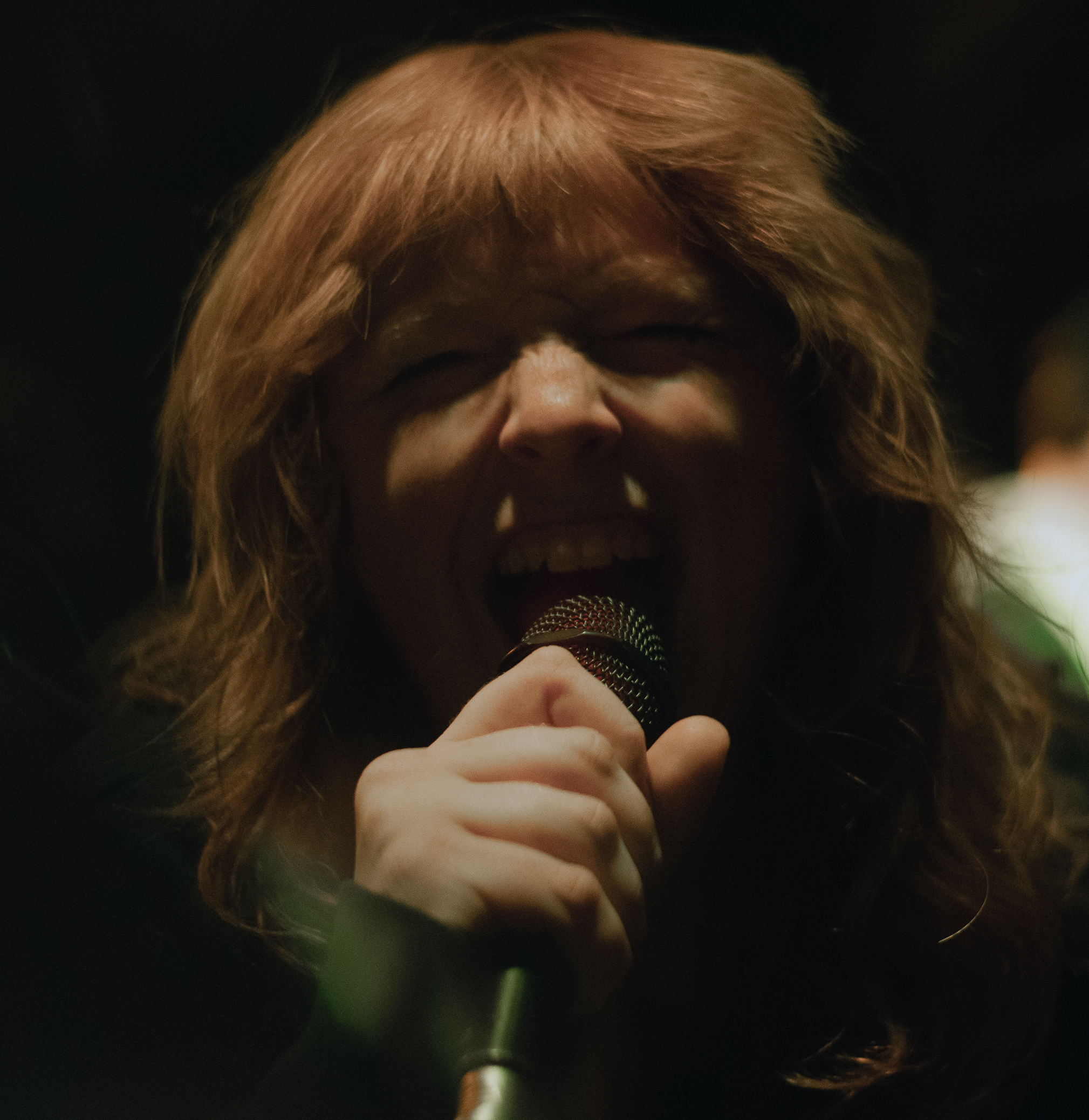 A singer belting into the microphone at The Camel