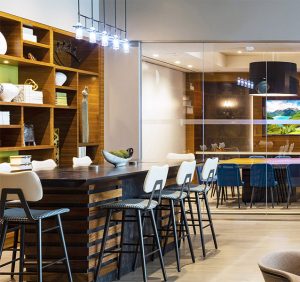 bookshelves with a grouping of green books, white books and other accessories, along with a black bar