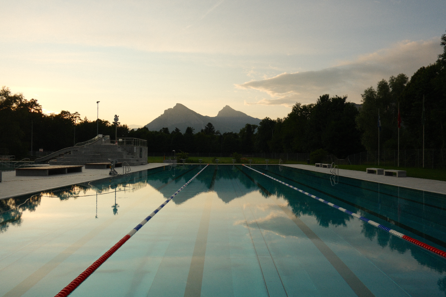 Giessenparkbad outdoor swimming pool in Bad Ragaz at sunset with mountains in the background