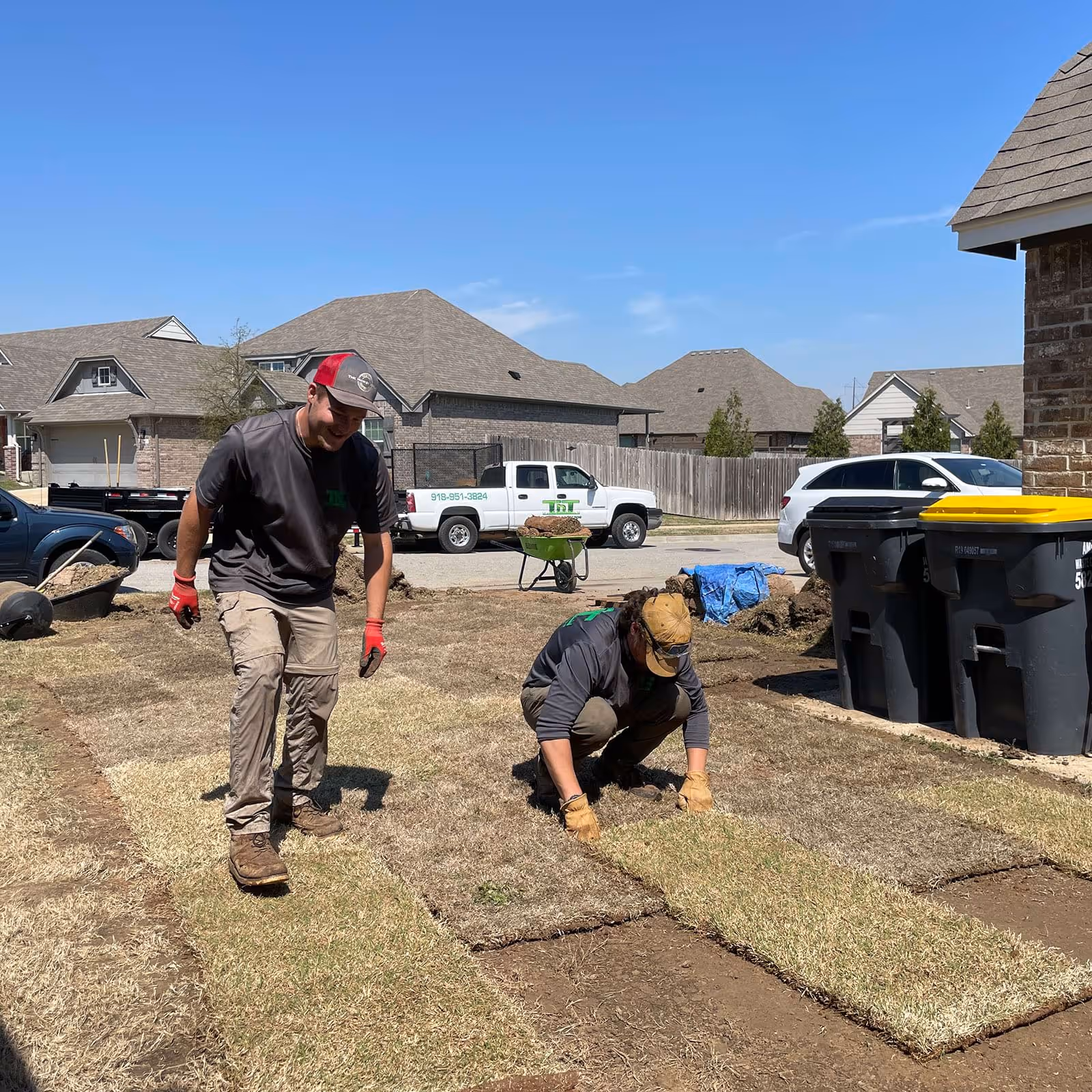 Worker laying sod for lawn improvement near me in Jenks by TnT Premier Landscape