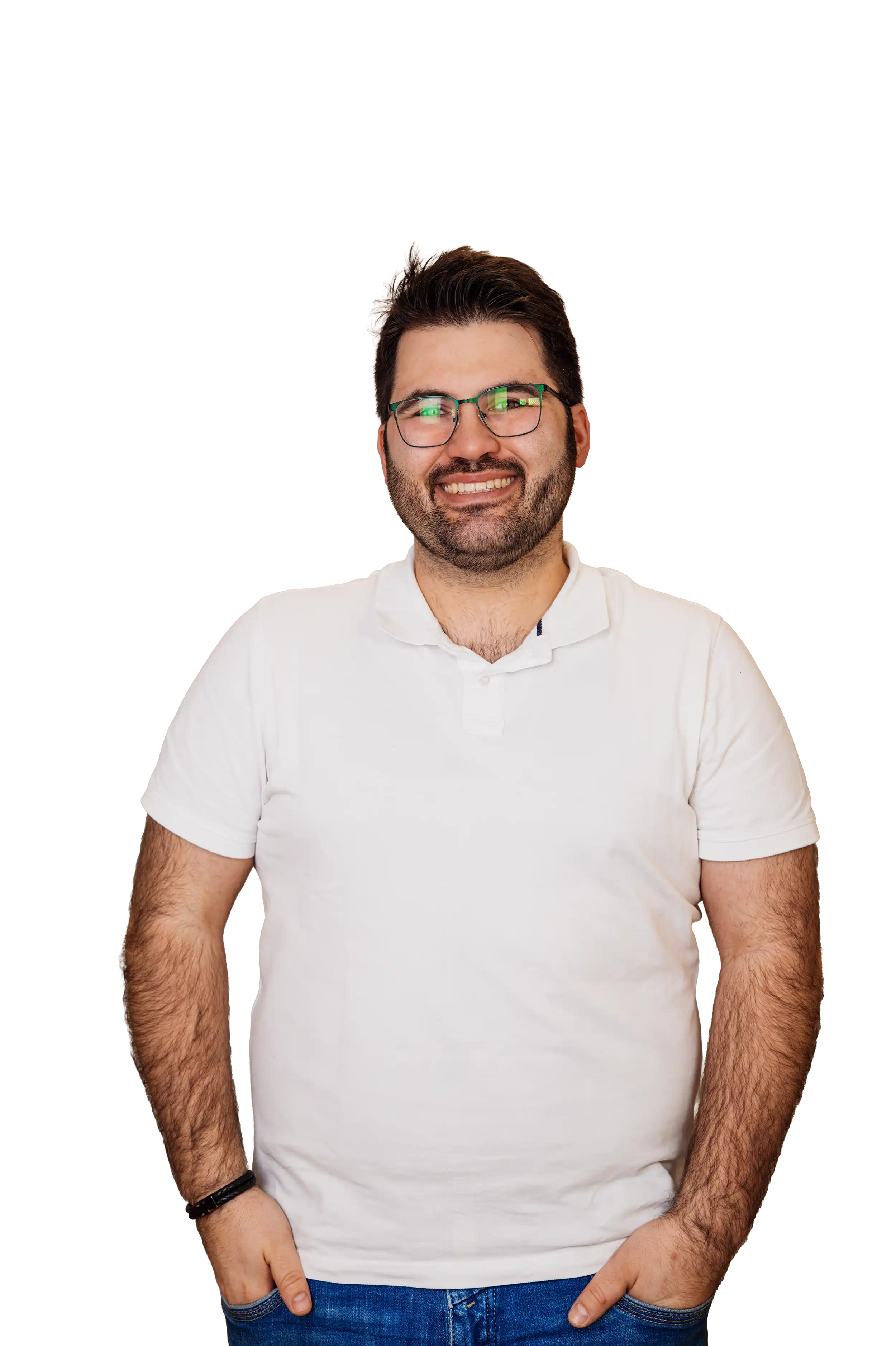 Lächelnder Mann mit Brille, weißem Polohemd und blauen Jeans, Hände in den Taschen.