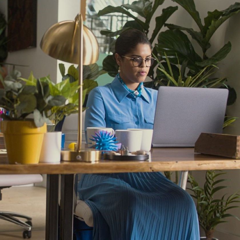 A person sits at a desk with a laptop in a modern workspace, illustrating focused digital data management.