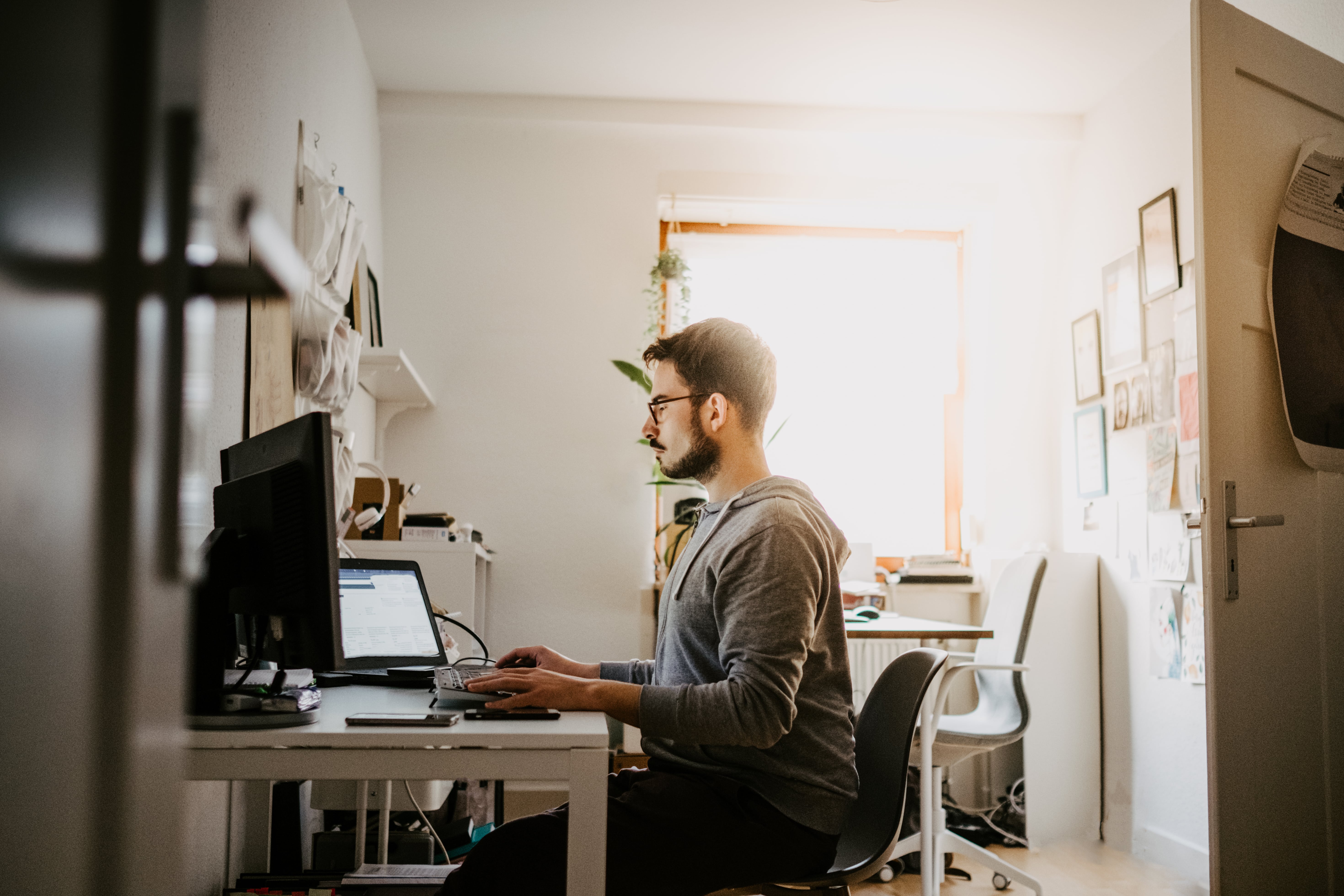 A person sits at their desk while concentrating on writing a follow up email.