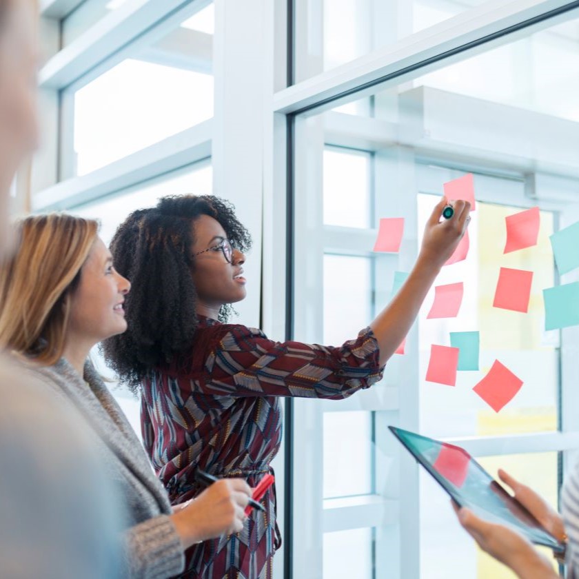 Team in a creative planning session, using sticky notes and visual aids to generate campaign ideas and organize content.
