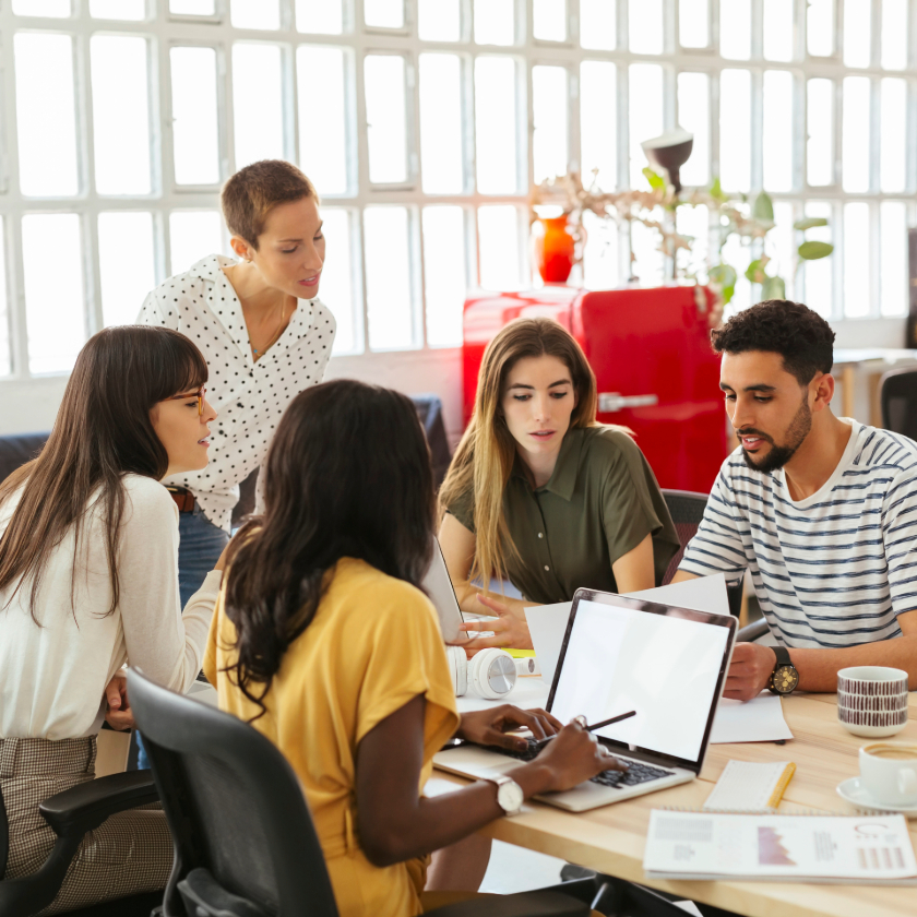 A creative team gathers around a meeting table discussing a project.