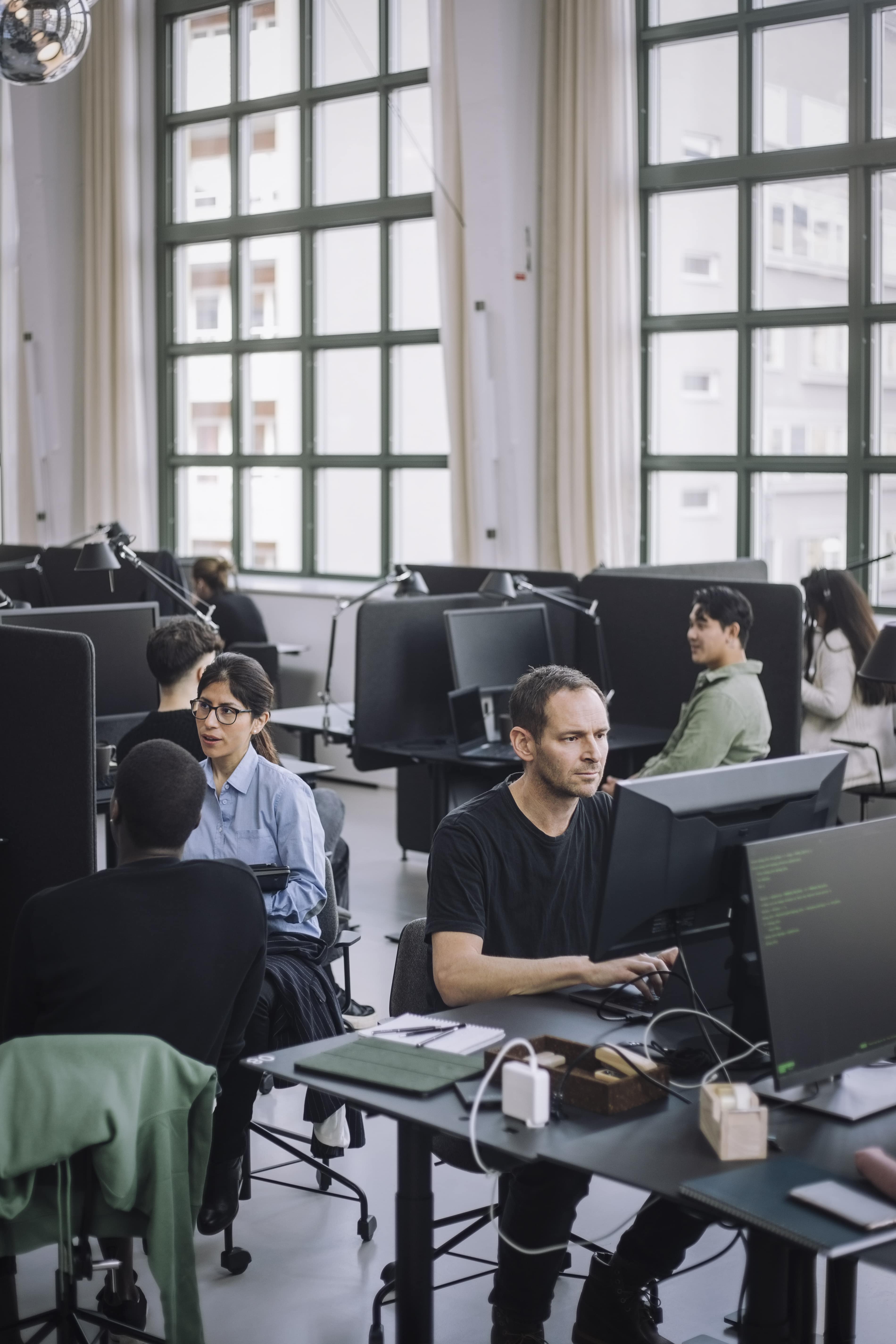 A sales and marketing team working together at desks in an open office, planning a content strategy using AI.
