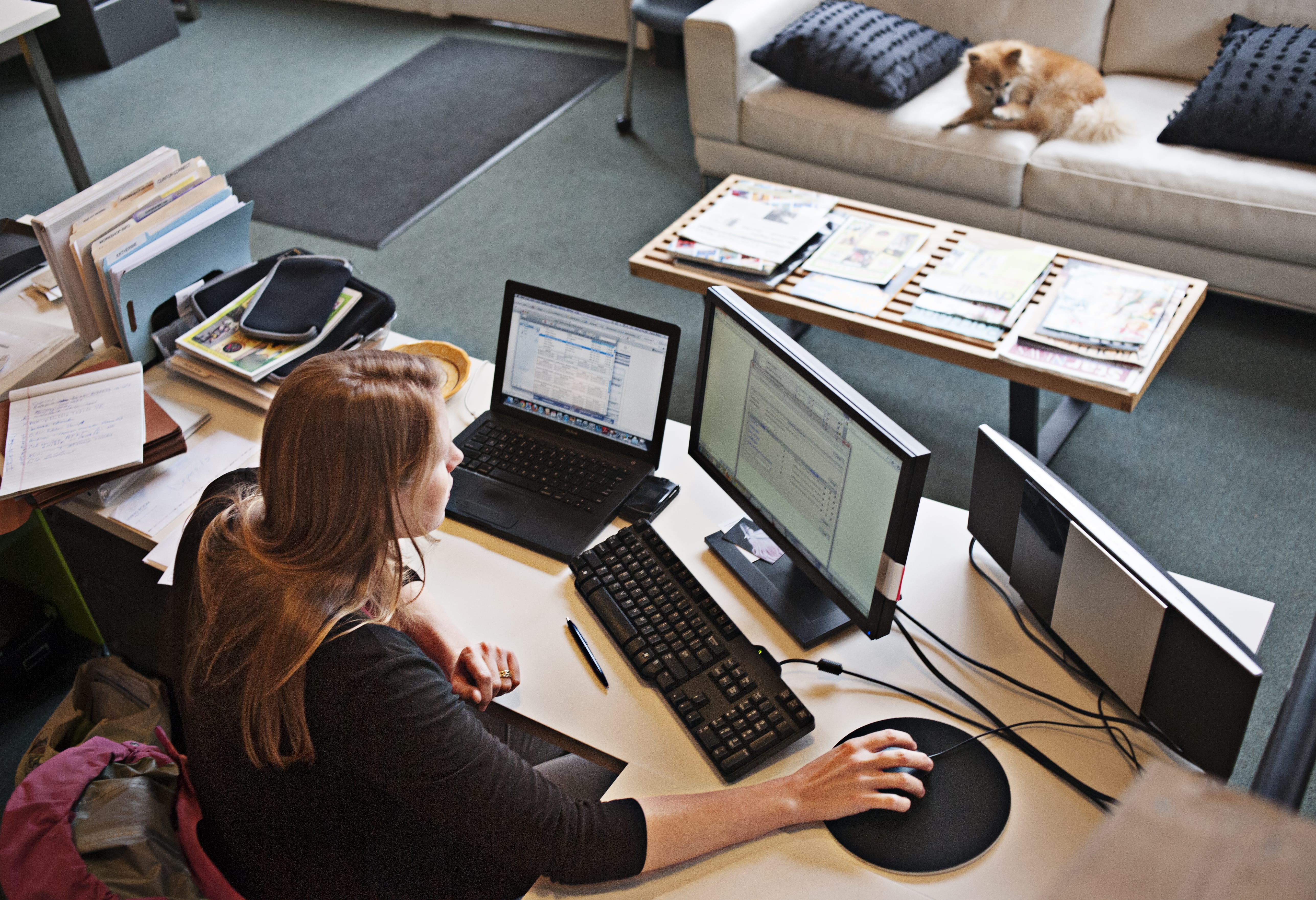 A person sits at their home workstation while analyzing data on their screen.