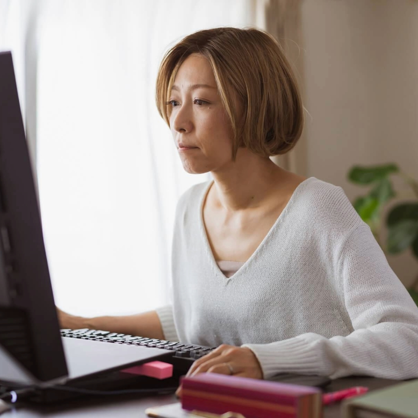A person sits at their home office desk while reading a summary of a deck on their computer.