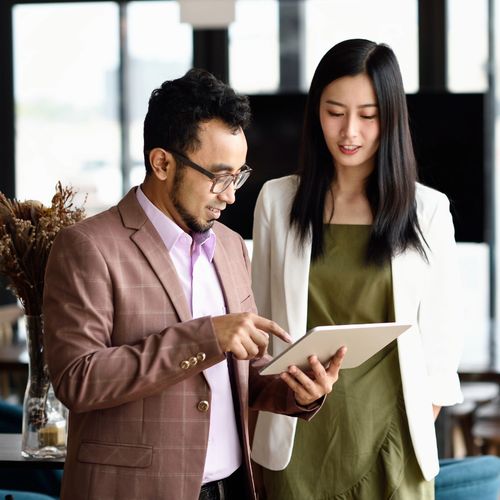 Two people check their notes ahead of giving a big presentation.