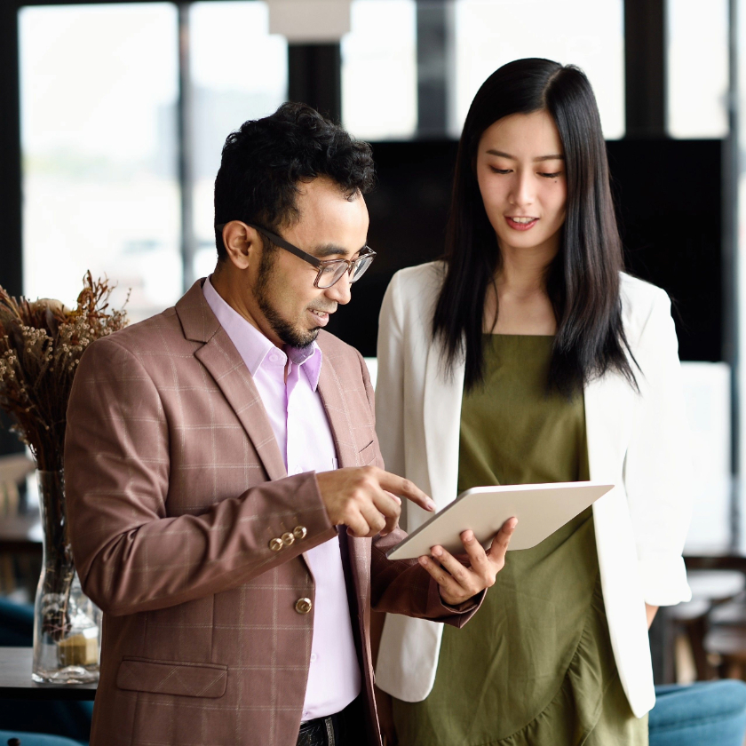 Two people check their notes ahead of giving a big presentation.