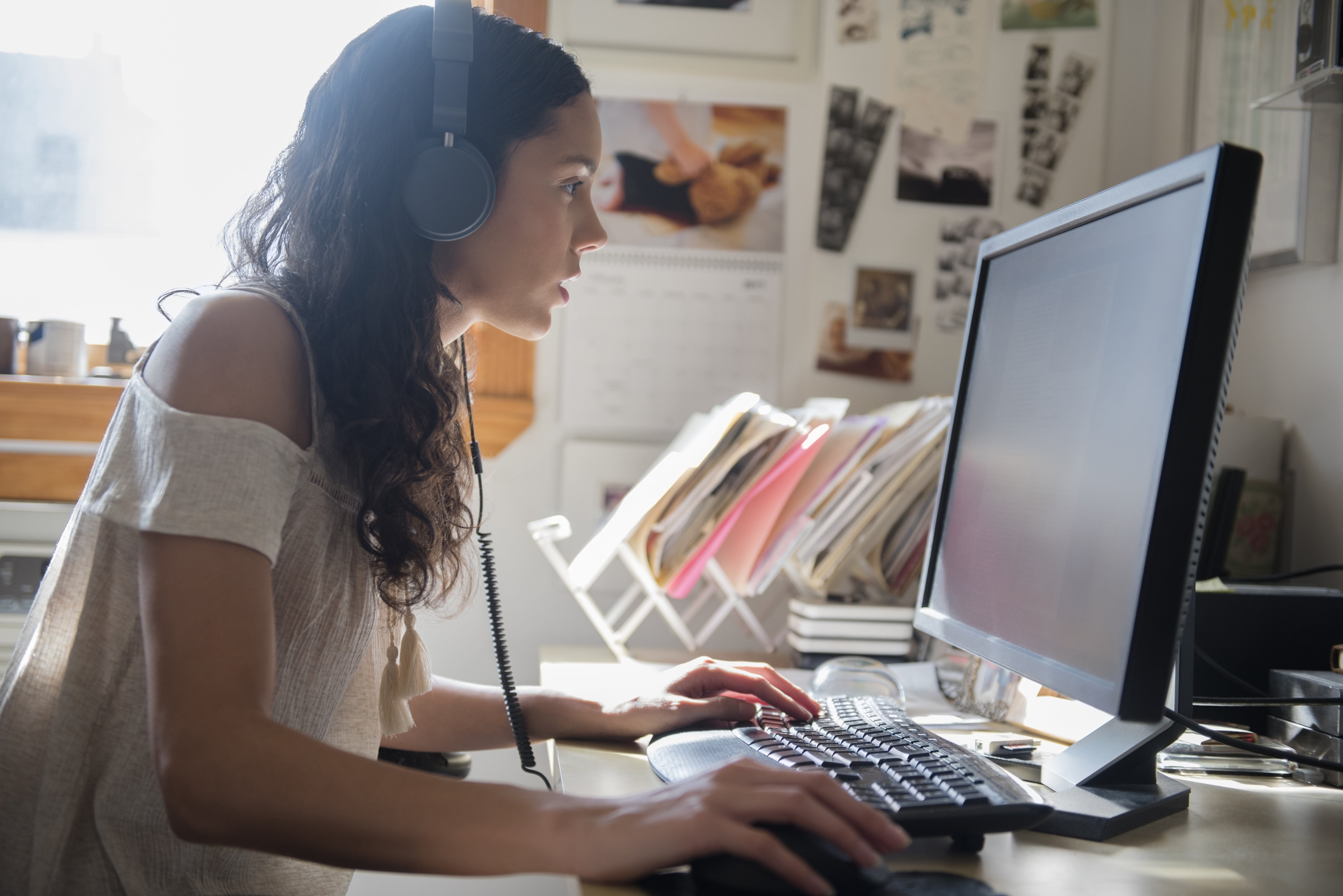 A person sits at their home office while zoned in on a creative task.