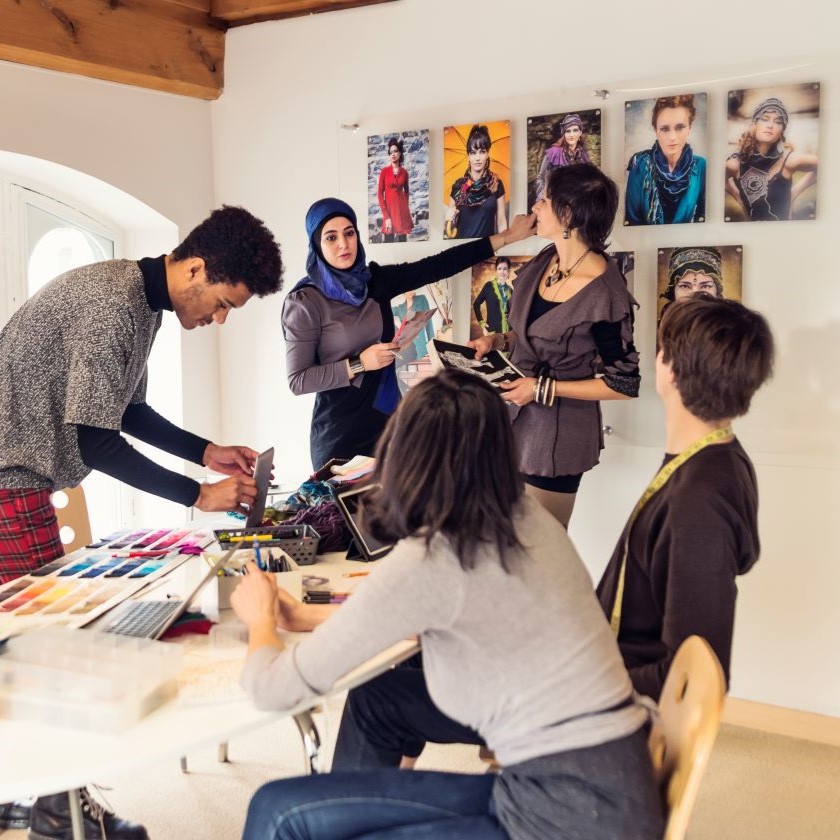 Creative team gathered around a table reviewing color palettes and visuals for a project launch.
