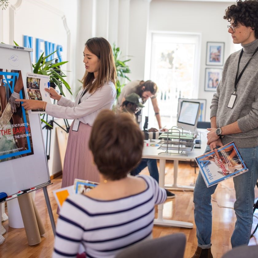 Creative team evaluates visual and copy layout for social campaign on whiteboard in shared office space.