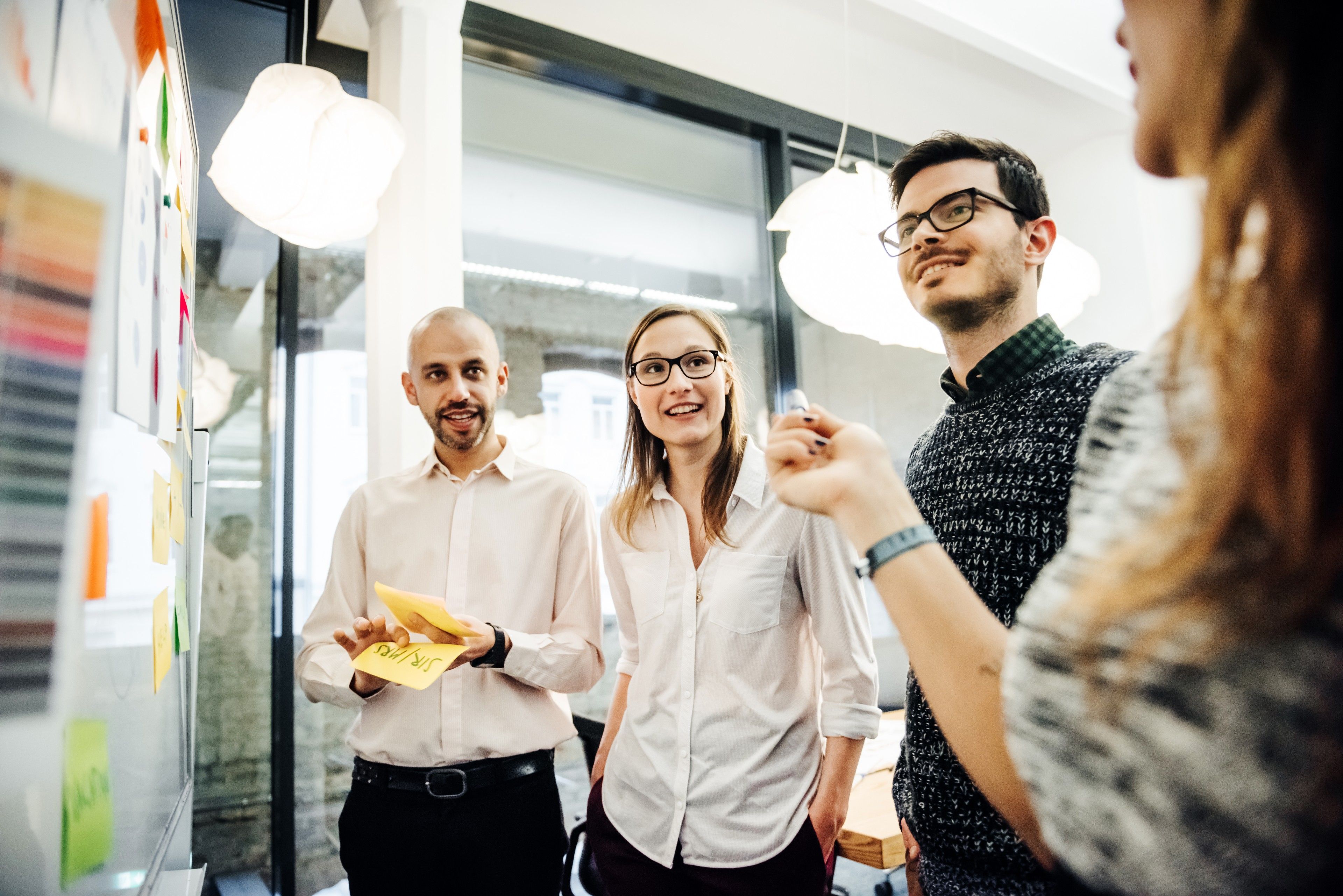 Colleagues collaborating during a planning session in a brightly lit office.