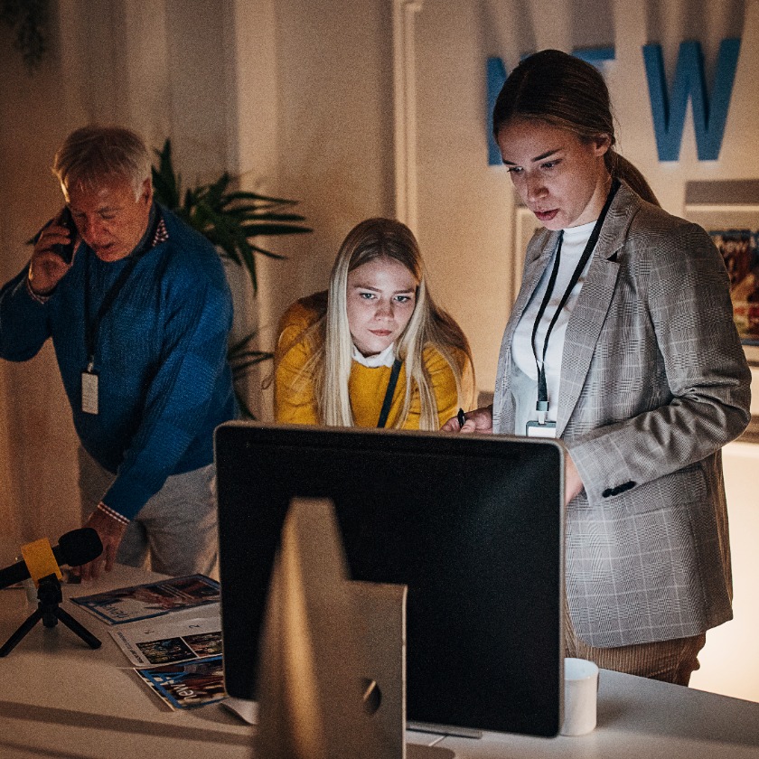 A group of people work late at night in an office while preparing for a project.
