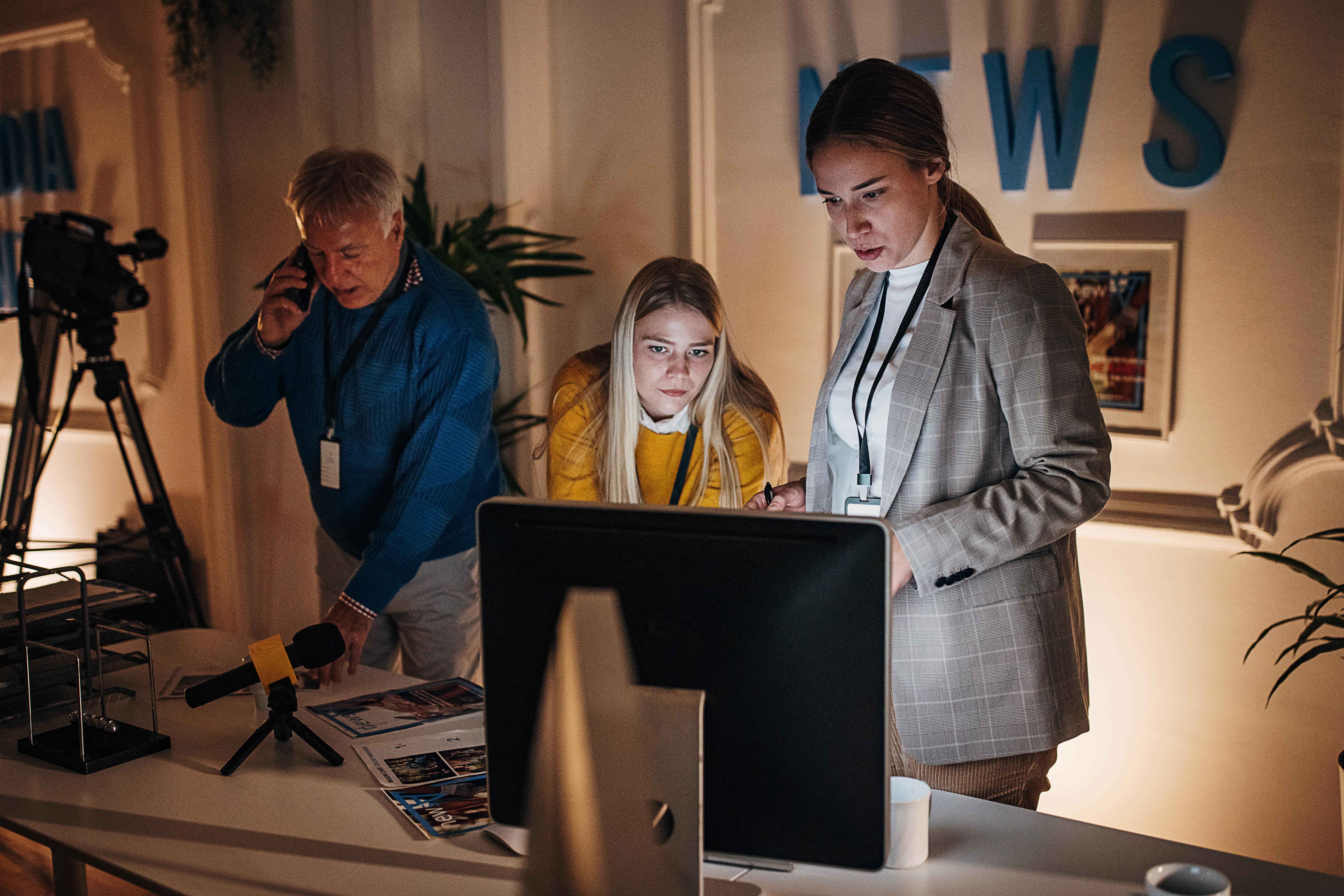 A group of people work late at night in an office while preparing for a project.