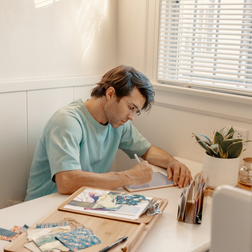 A person uses their tablet device to work on a creative project.