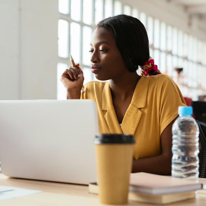 A person reviewing ad copy draft on laptop, appearing thoughtful and focused during work session.