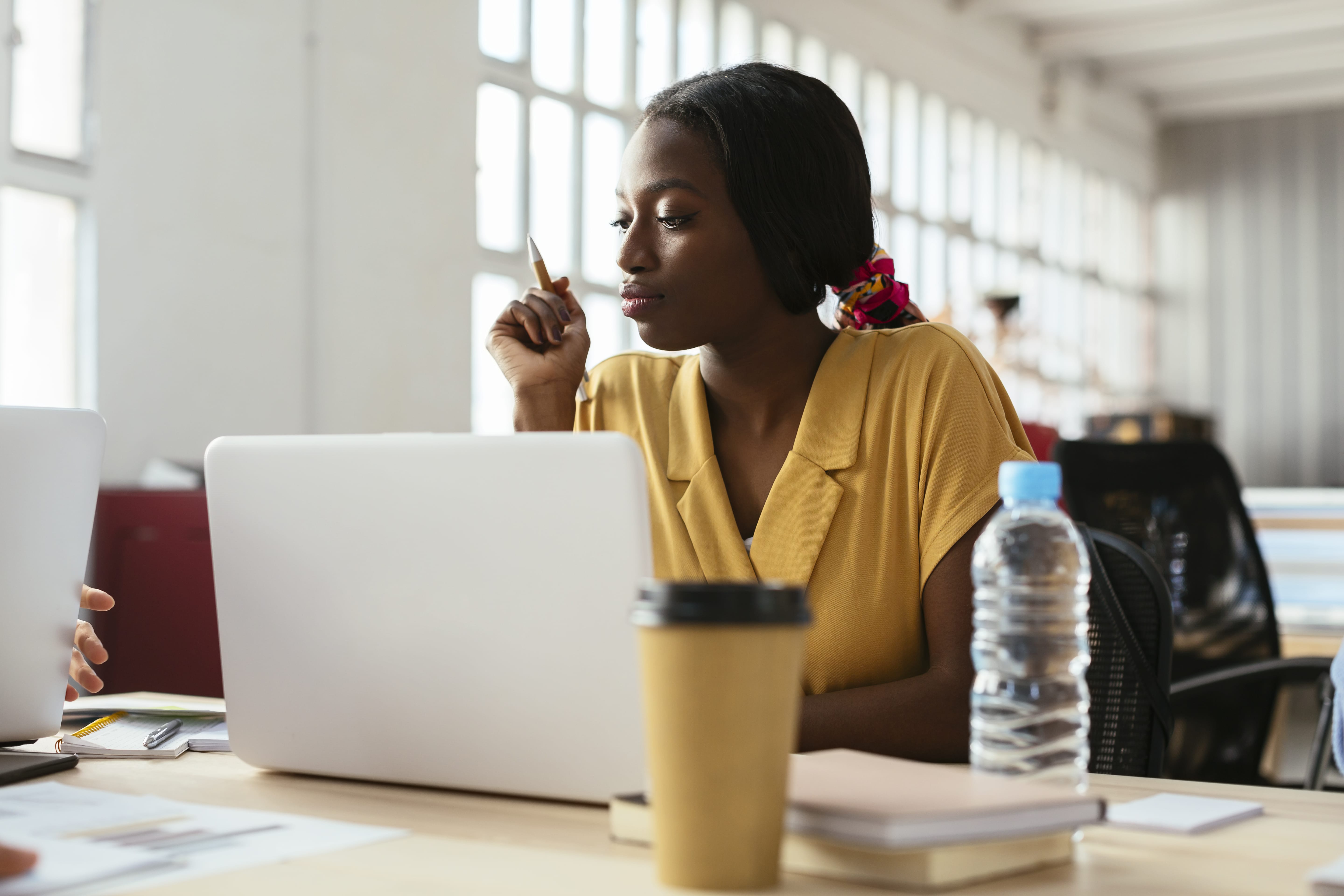 A person reviewing ad copy draft on laptop, appearing thoughtful and focused during work session.