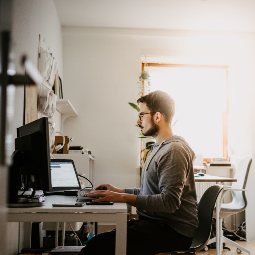 Remote worker reviewing digital files at desktop, illustrating document control in action.