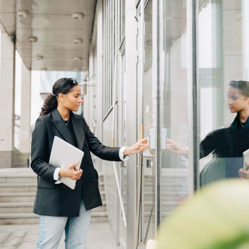 A person enters a code into a keypad to unlock a secure door.