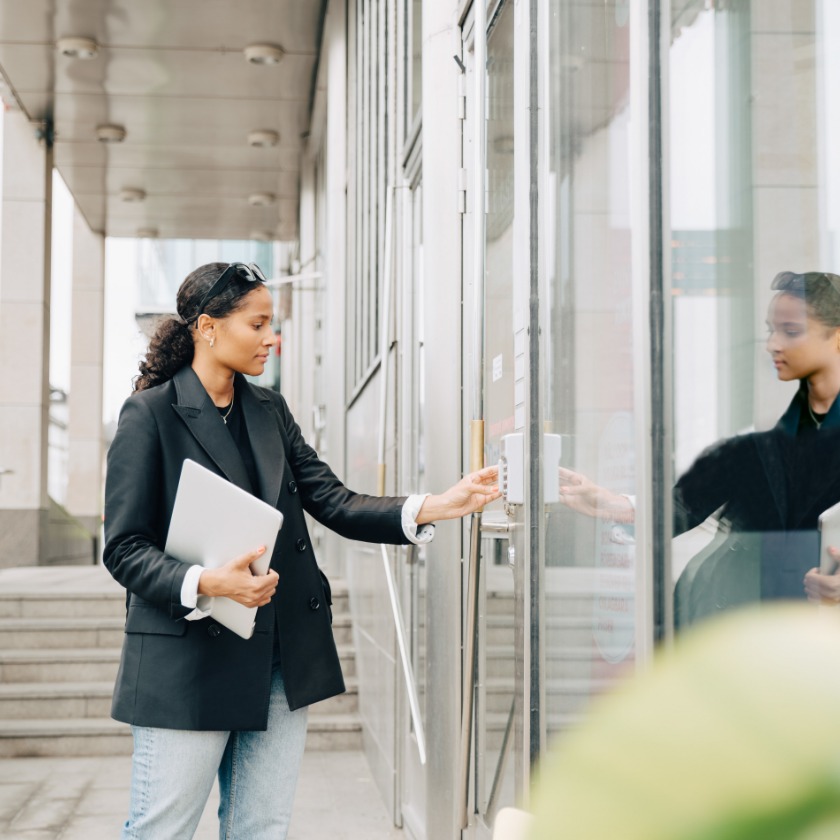 A person enters a code into a keypad to unlock a secure door.