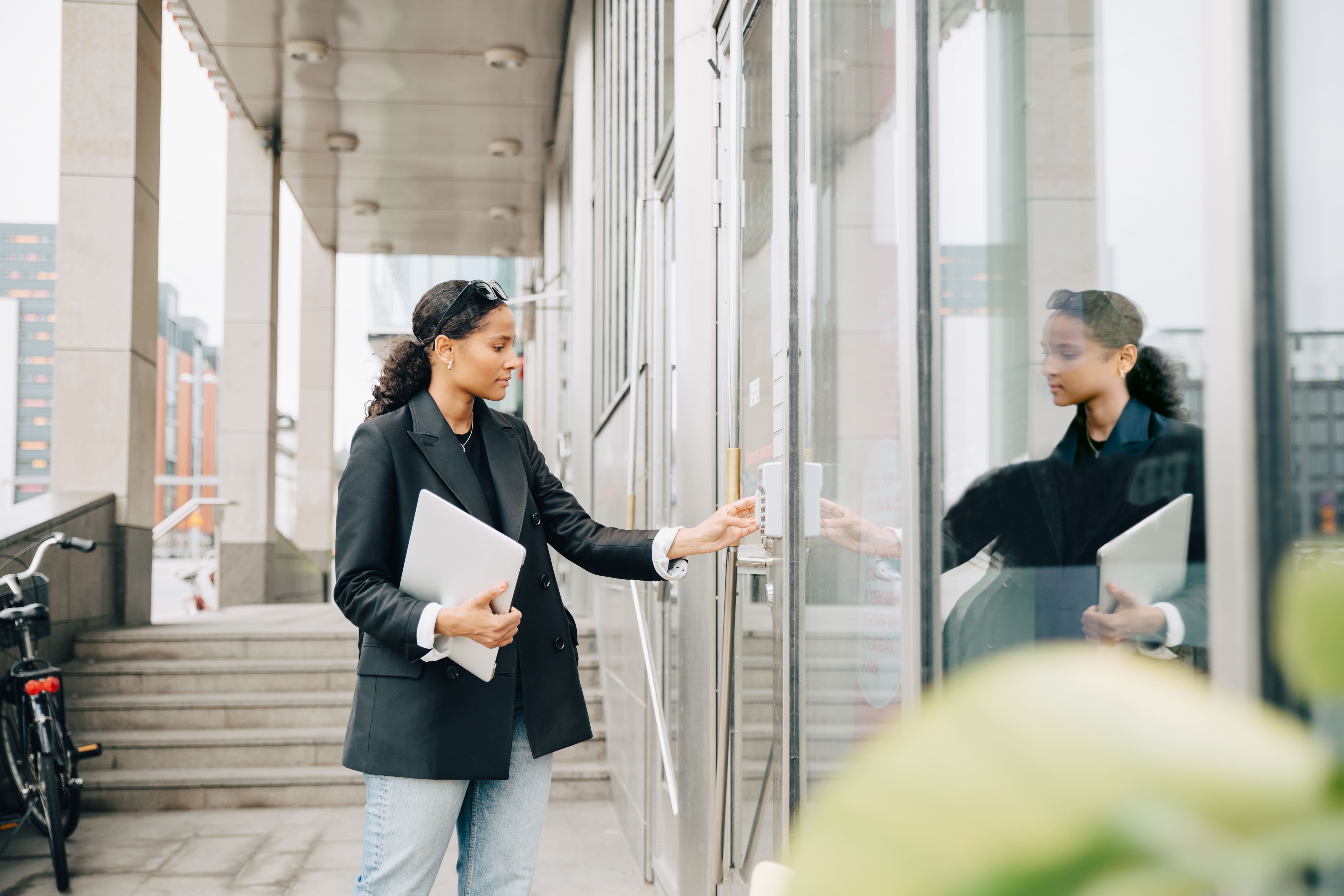 A person enters a code into a keypad to unlock a secure door.