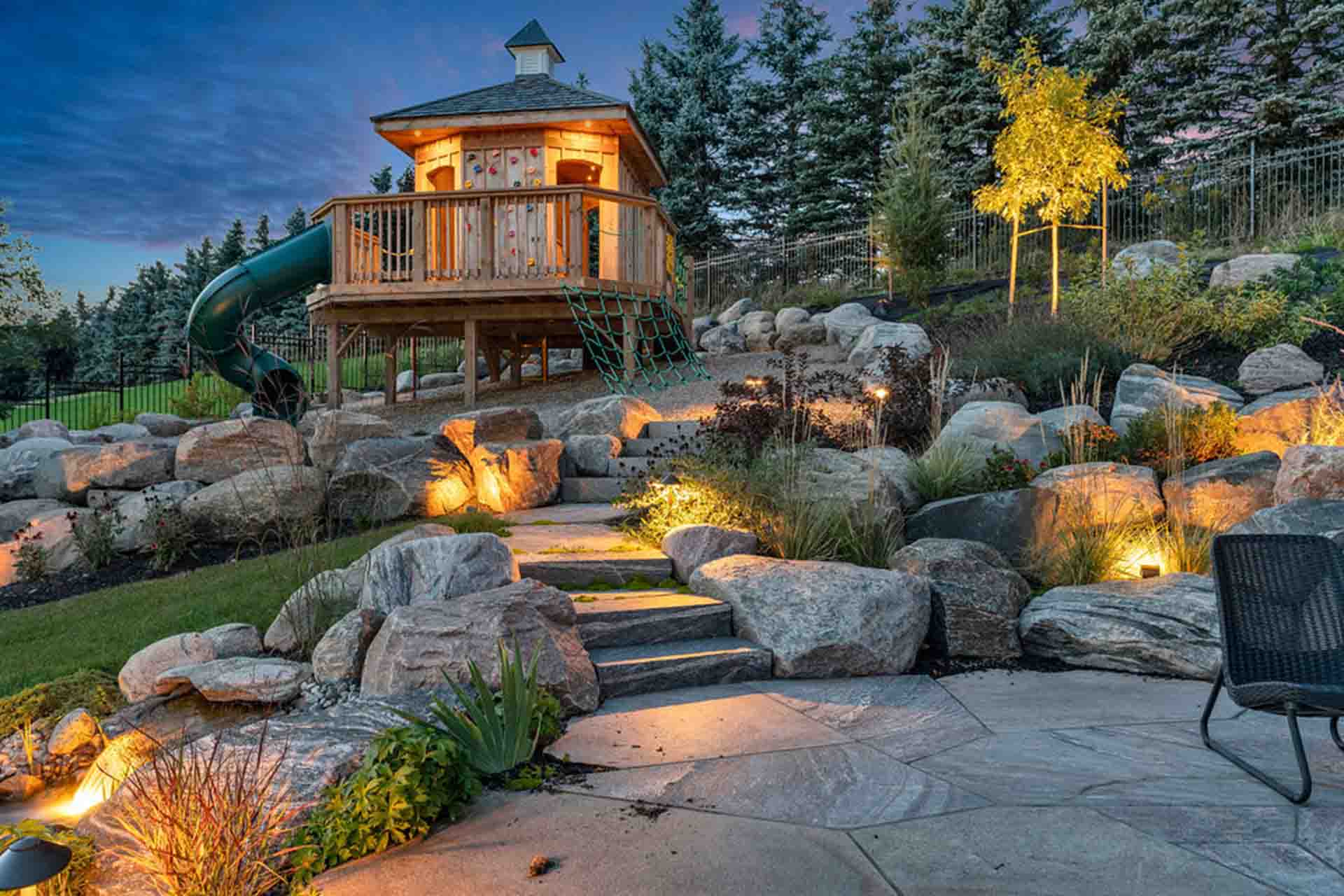 Landscape lighting on ornamental trees - walkways - and lush perennial beds in a private backyard.