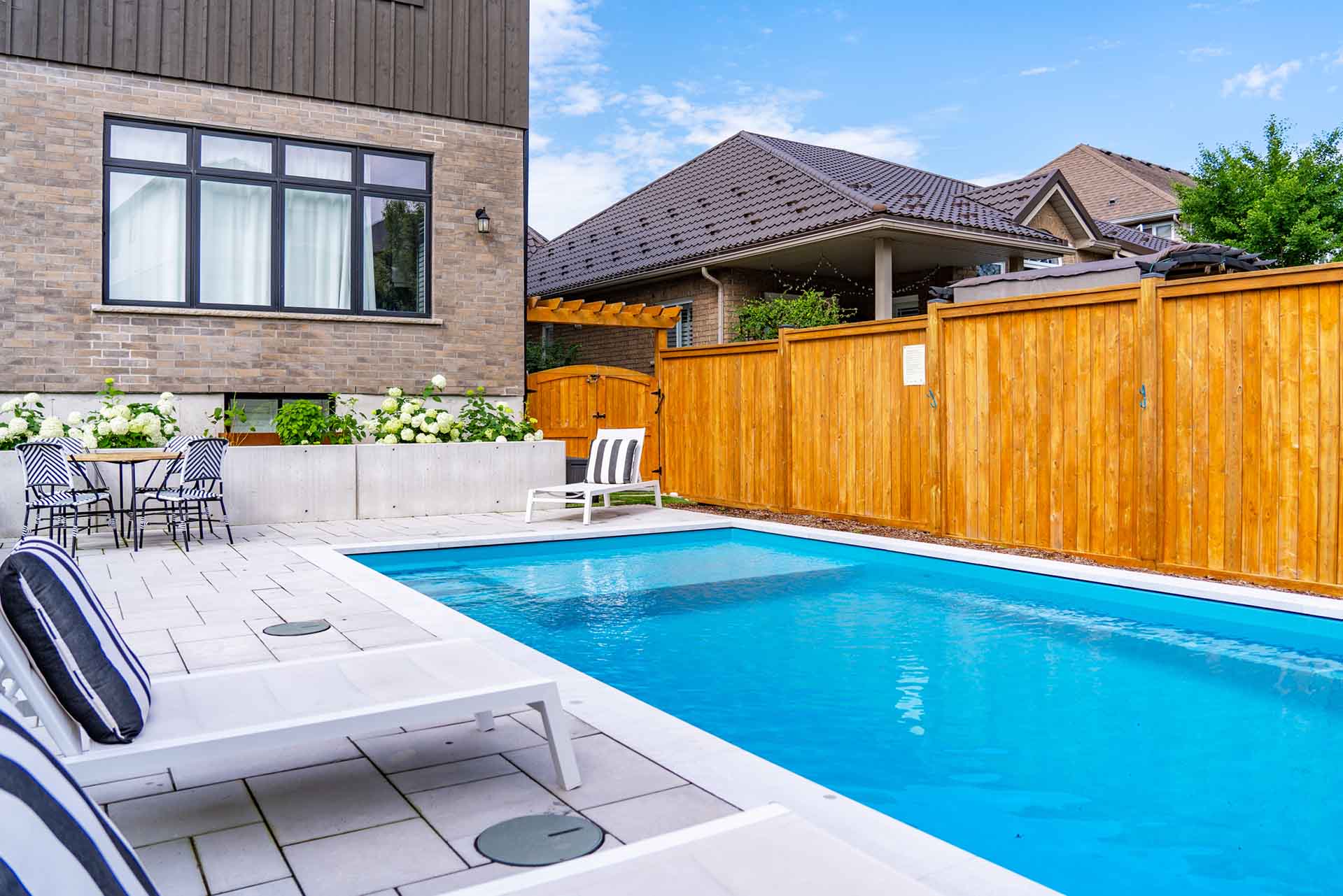 Custom in-ground swimming pool integrated with landscaped backyard.