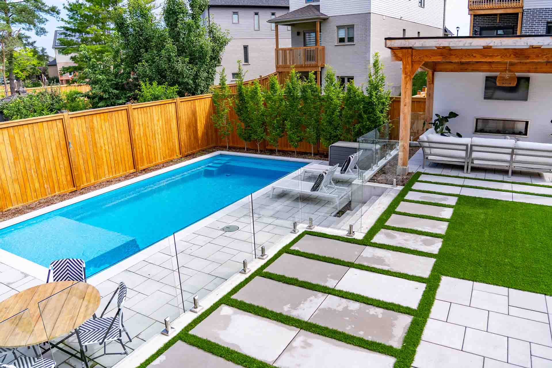Custom in-ground swimming pool integrated with landscaped backyard.