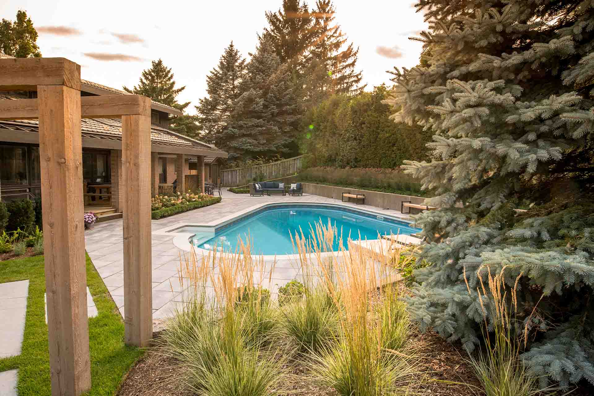 Modern in-ground swimming pool with surrounding stone patio.