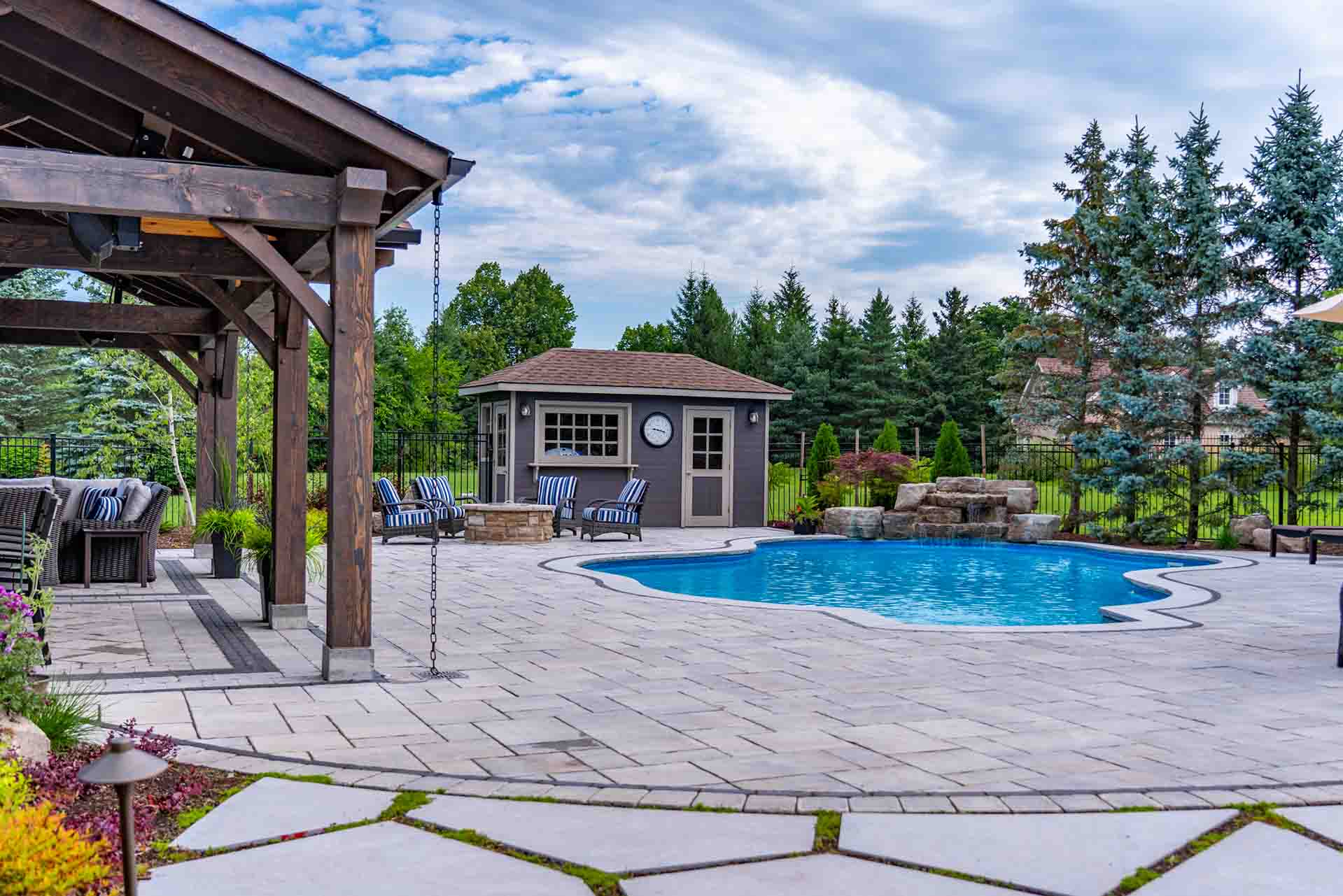 In-ground pool framed by professional landscape and patio design.