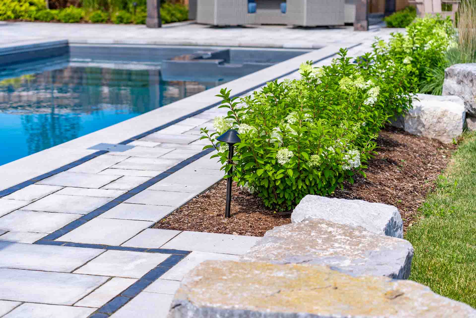 In-ground pool integrated with hardscape, planting, and outdoor amenities.