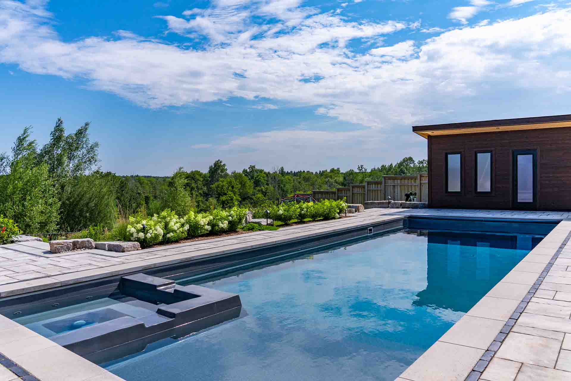 In-ground pool integrated with hardscape, planting, and outdoor amenities.
