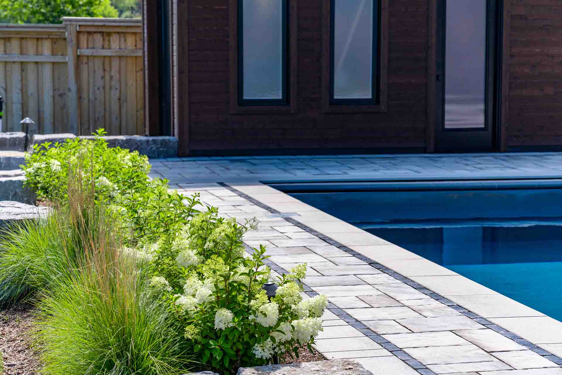 In-ground pool integrated with hardscape, planting, and outdoor amenities.