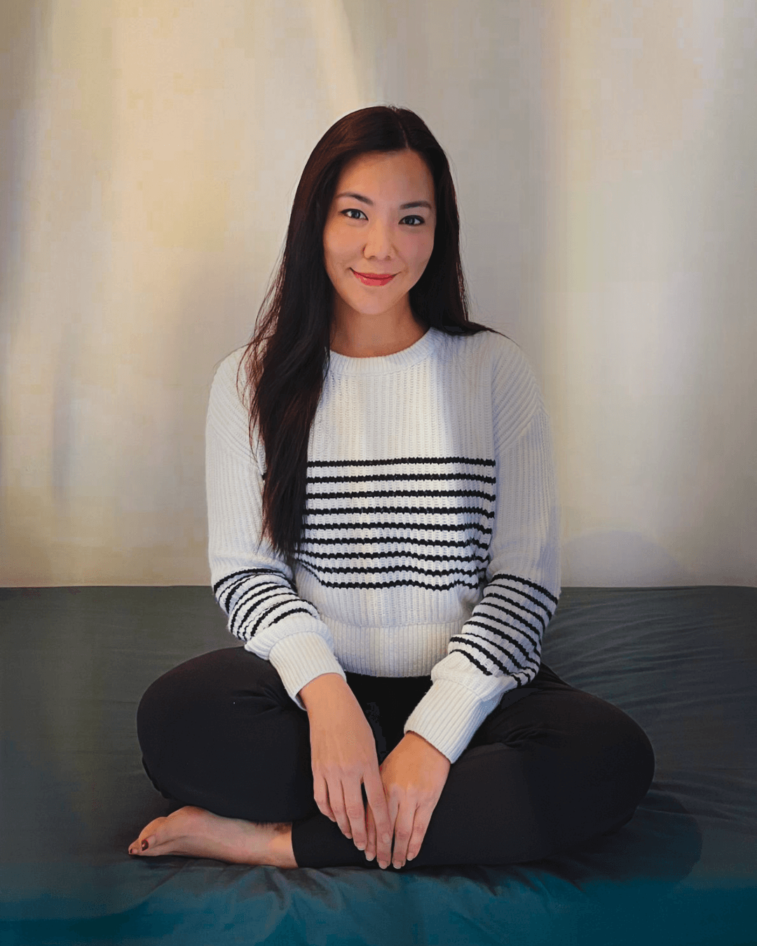 Ash, a breathwork facilitator at No Name Studios smiling at the camera.