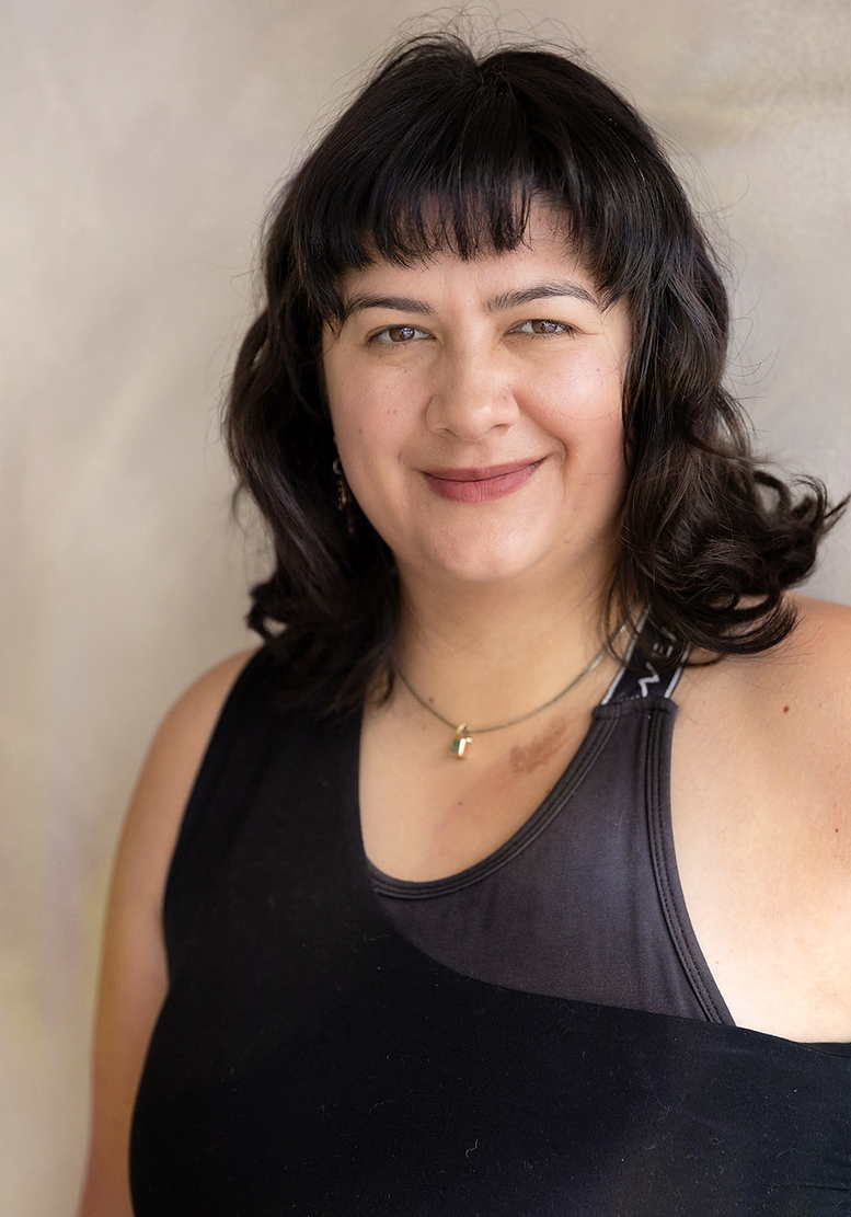 Ash, a breathwork facilitator at No Name Studios smiling at the camera.