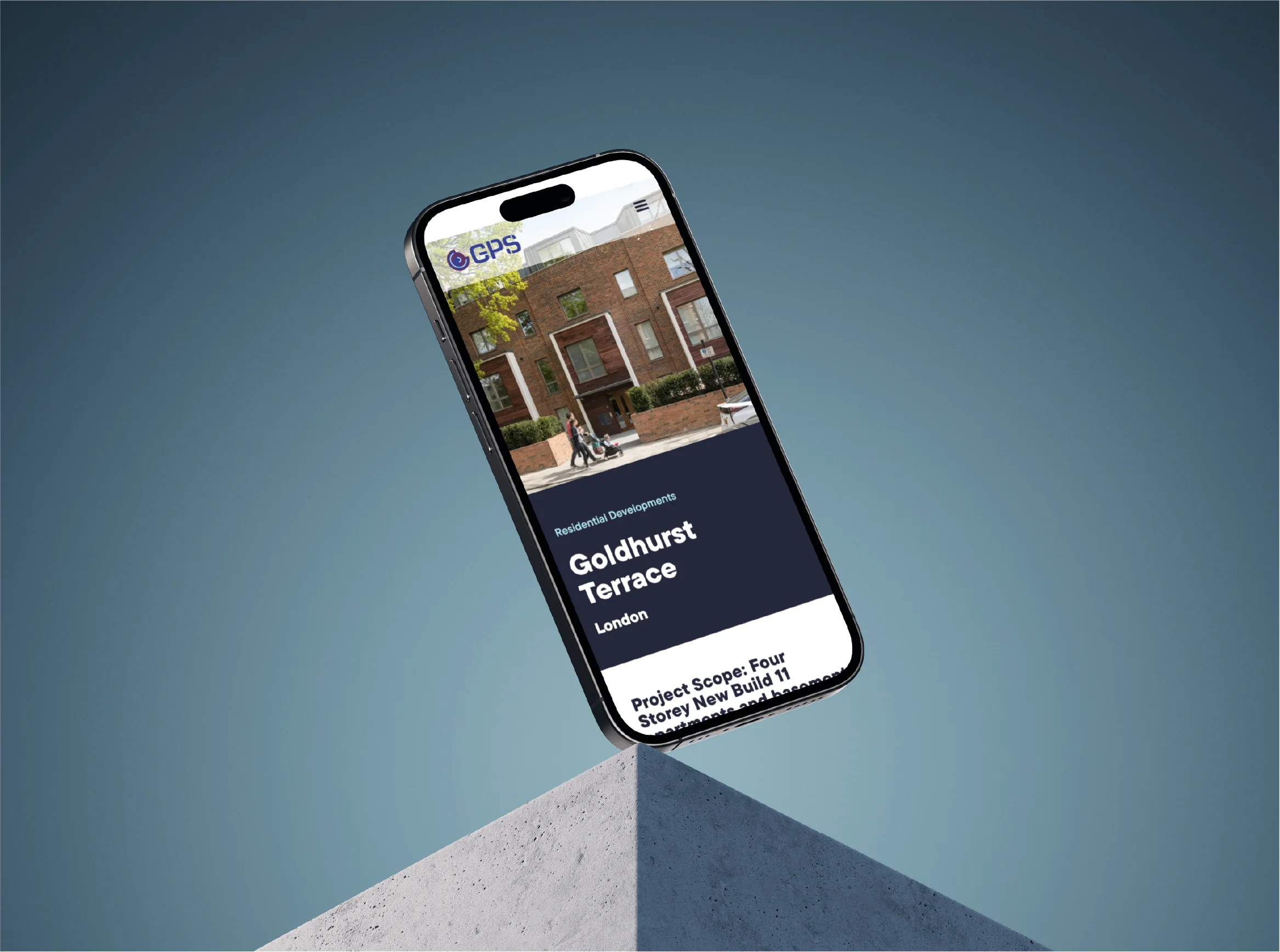 Smartphone displaying a webpage for Goldhurst Terrace residential development in London, shown tilted above a concrete pedestal against a blue background.