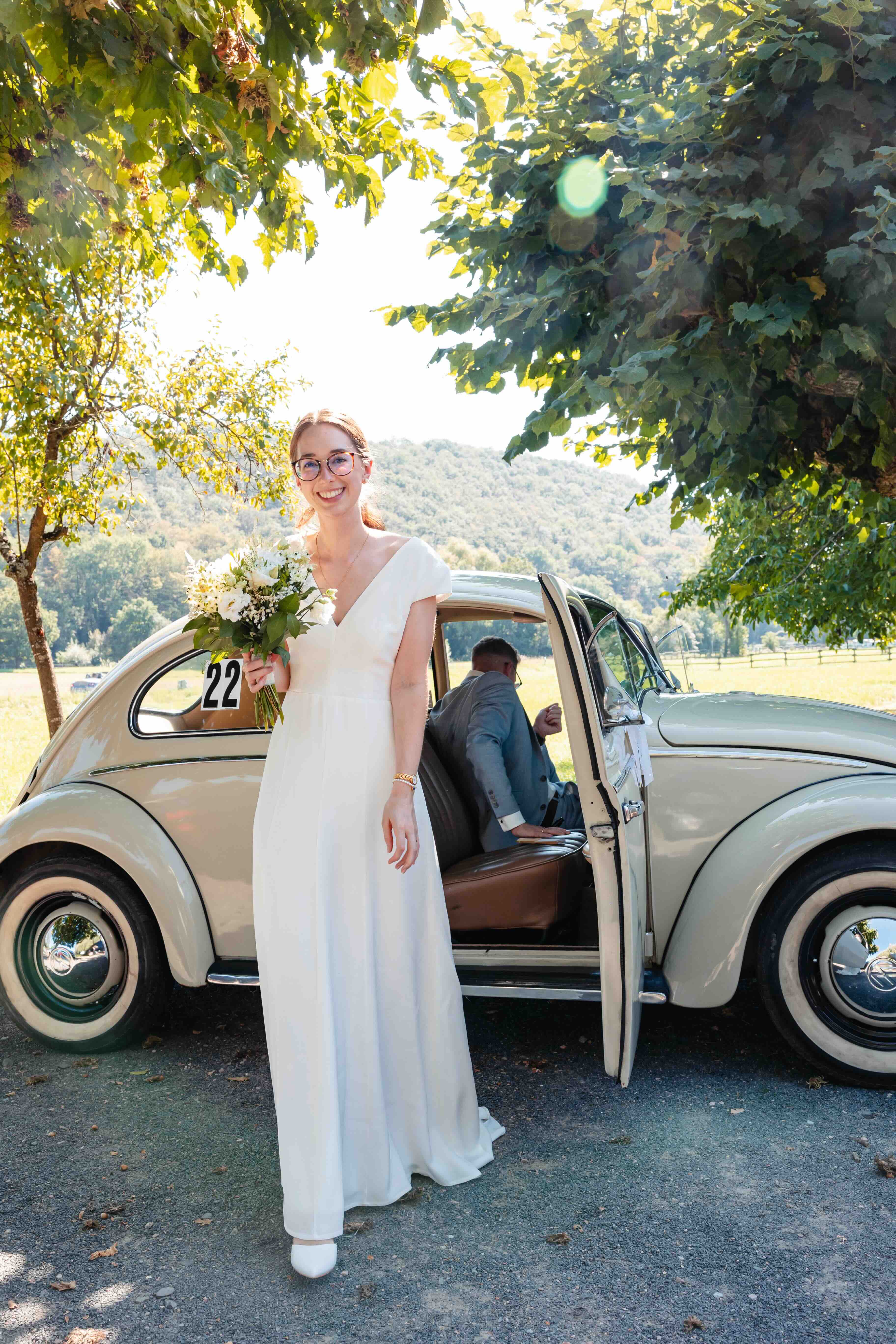 bride getting out of a car with her wedding bouquet in hand