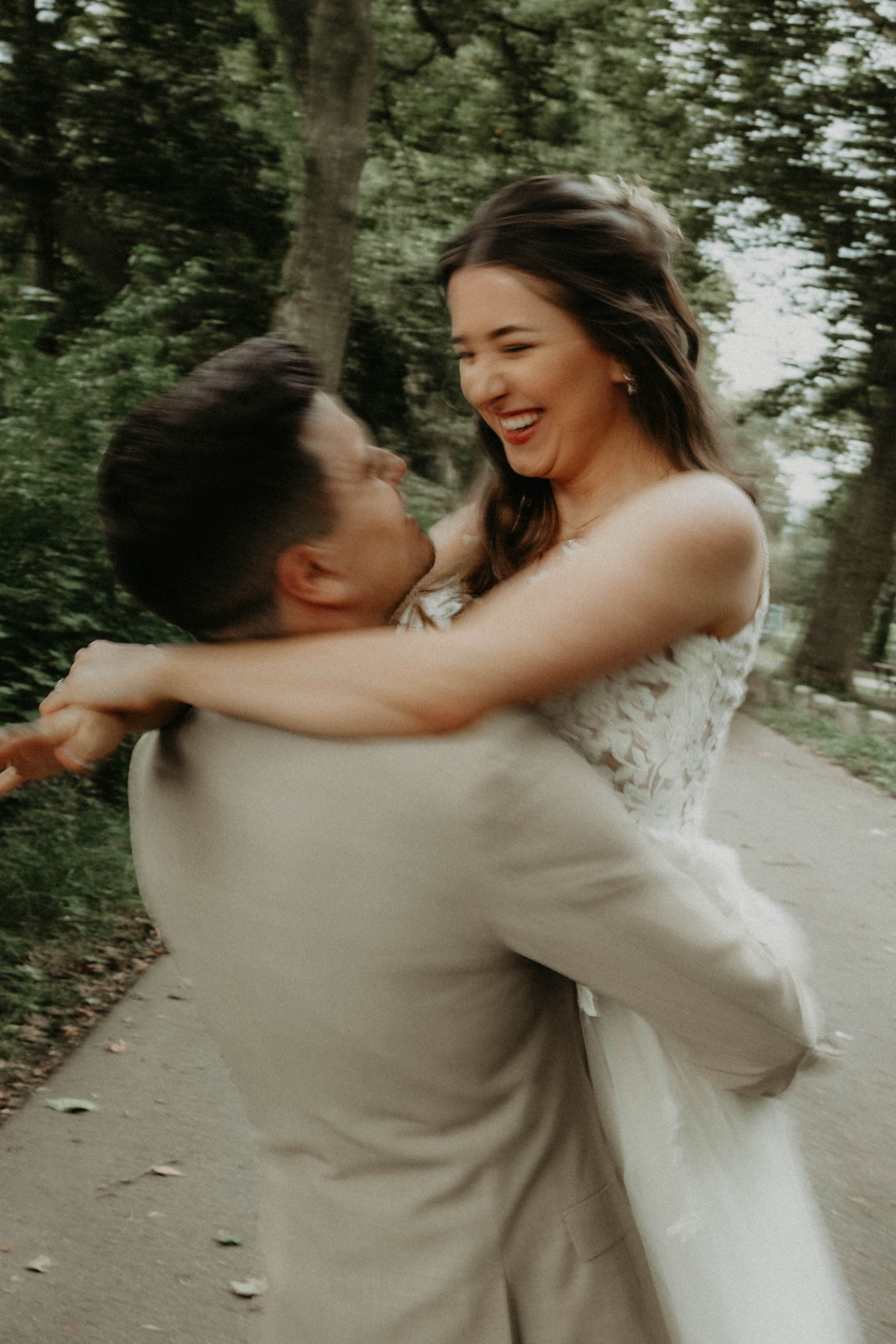 bride and groom hugging each other on a path in a park