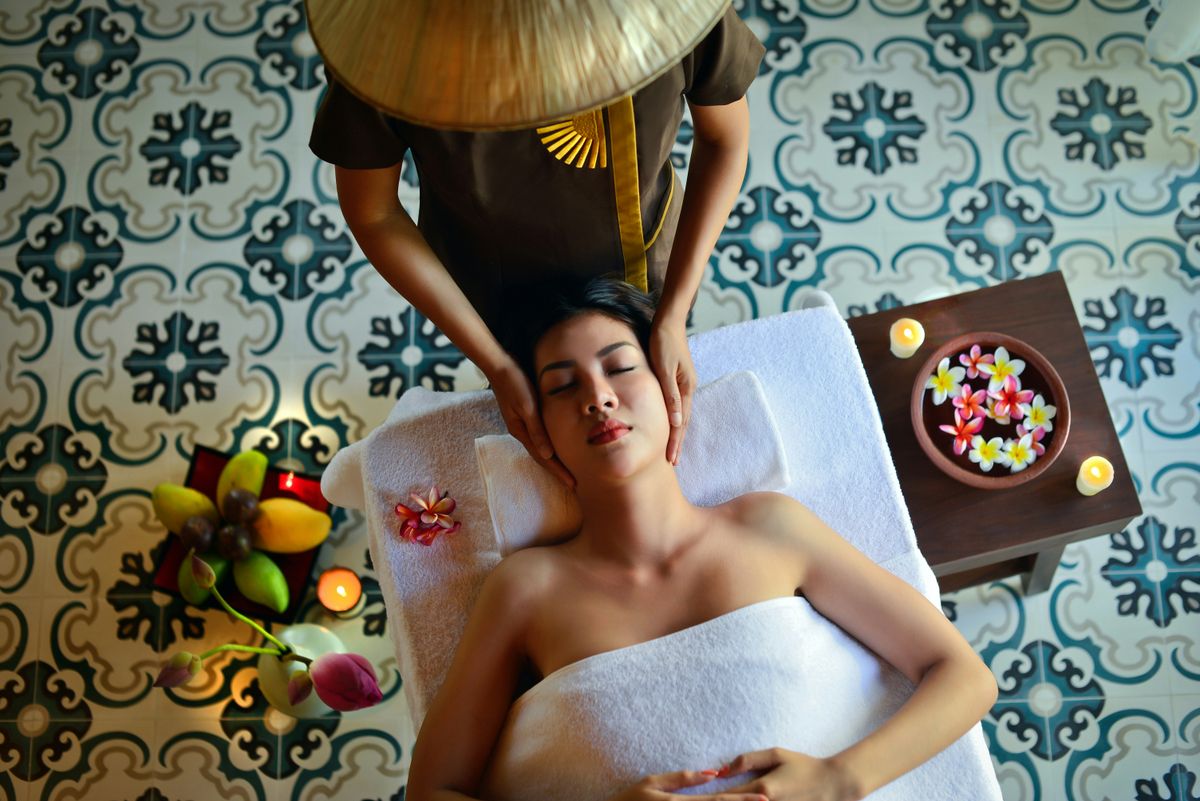 Relaxed woman face receiving a head massage in a spa setting
