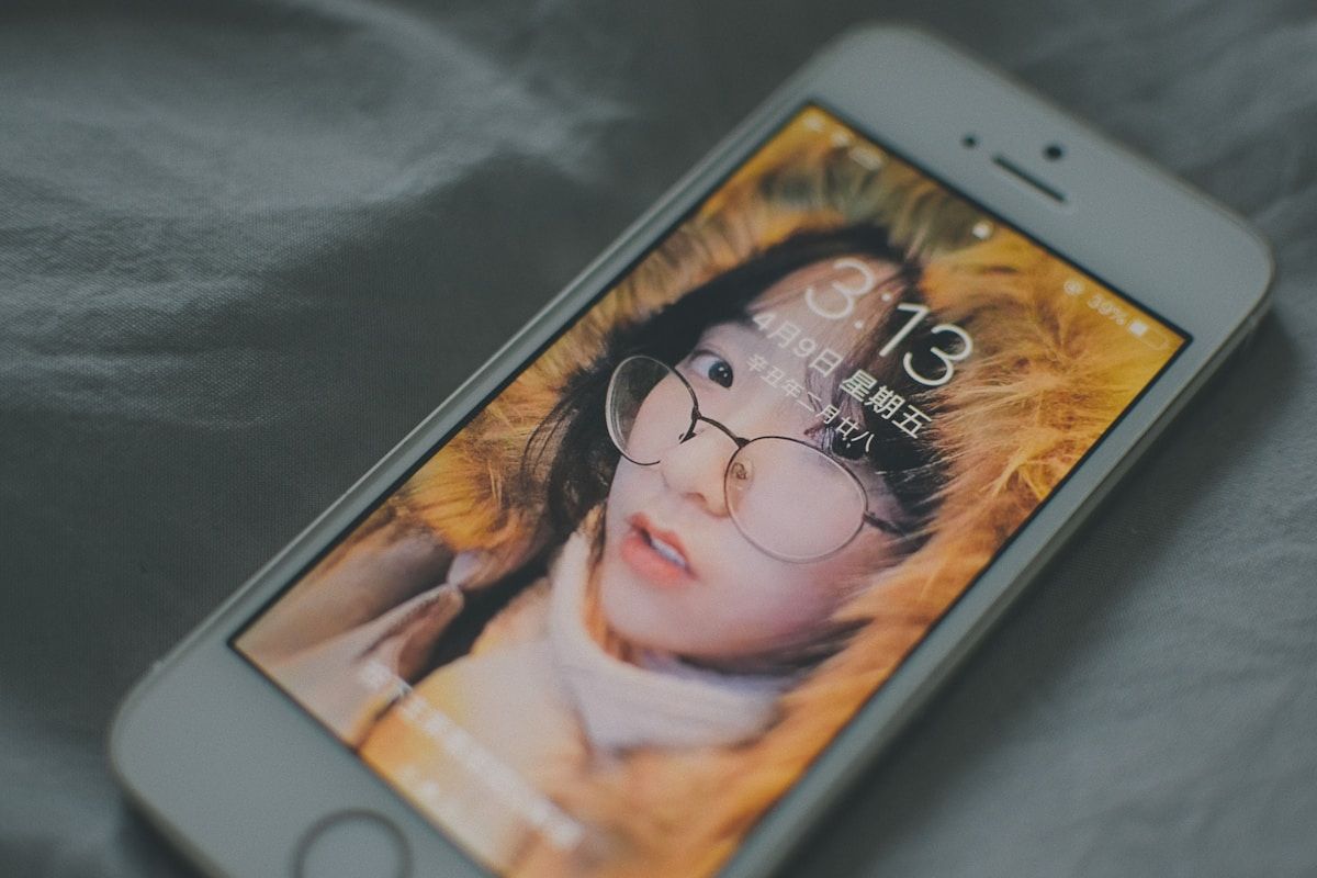 white iphone 5 on black textile