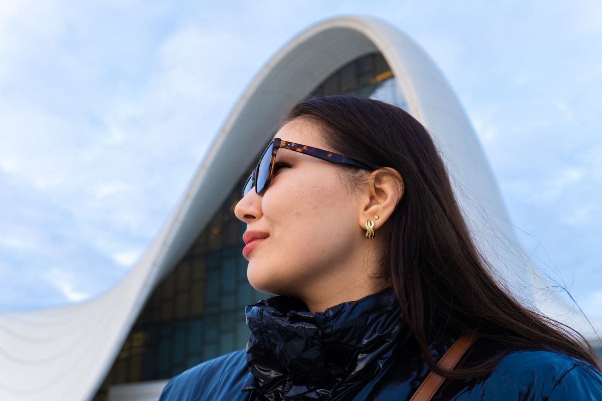 Woman poses by a modern, white architectural marvel.